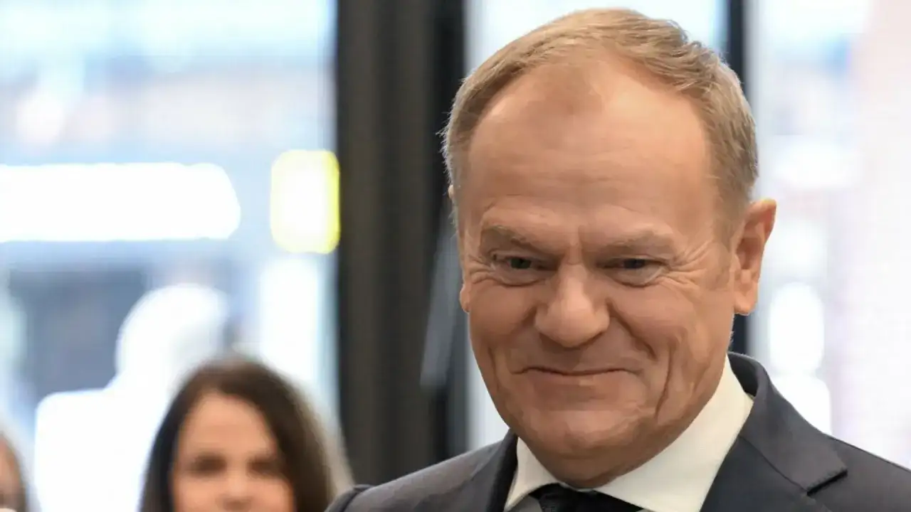 Uśmiechnięty Donald Tusk w garniturze. Ciekawe, ile Tusk ma emerytury na rękę, gdyby ją pobierał.