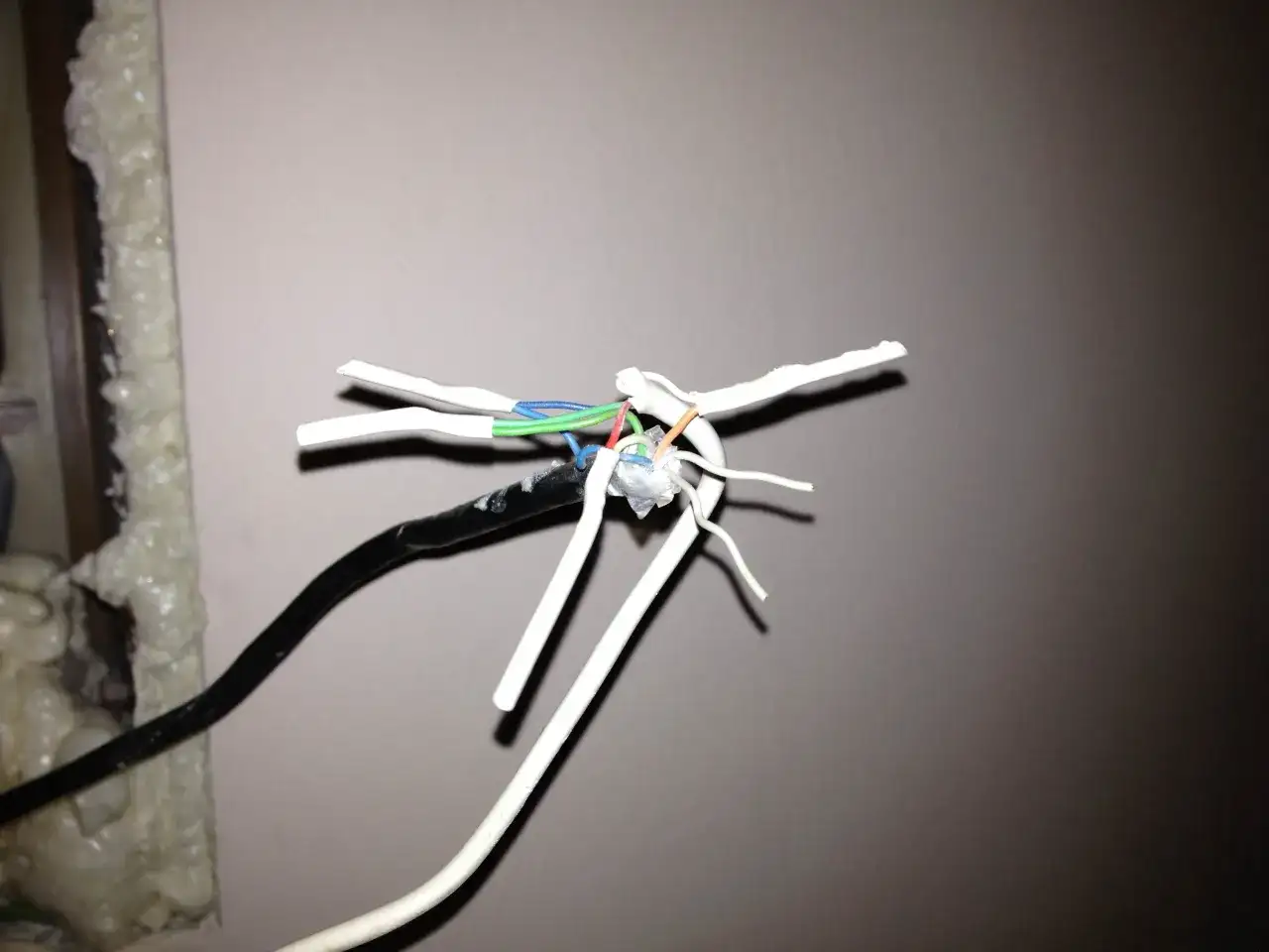 Przewody domofonowe w bloku, 6 żył. Widoczne gołe końcówki kabli, niebieski, zielony, czerwony i pomarańczowy.