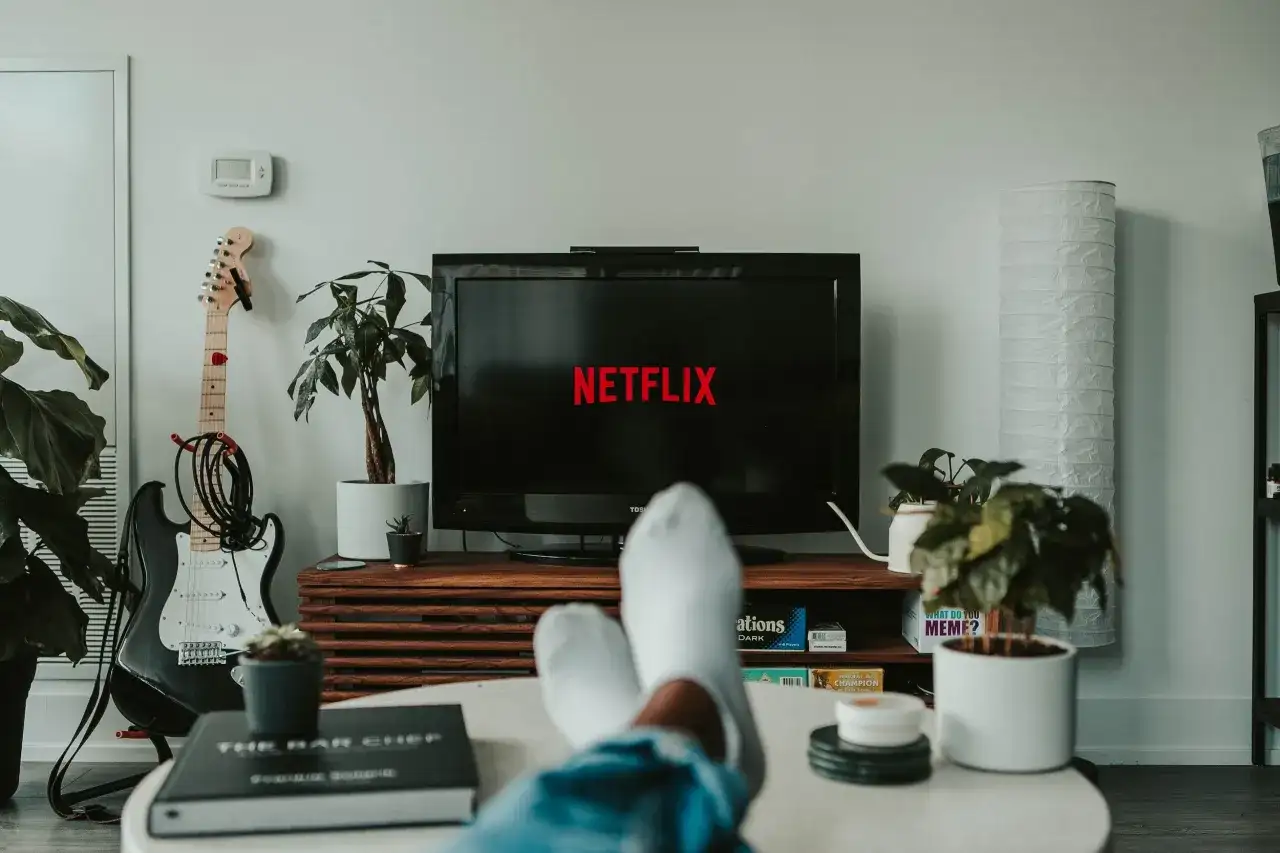 Relaks przy Netflixie to świetny sposób na naukę angielskiego z filmów i seriali. Wygodnie rozłożony na kanapie, z gitarą w tle, zanurzasz się w języku.