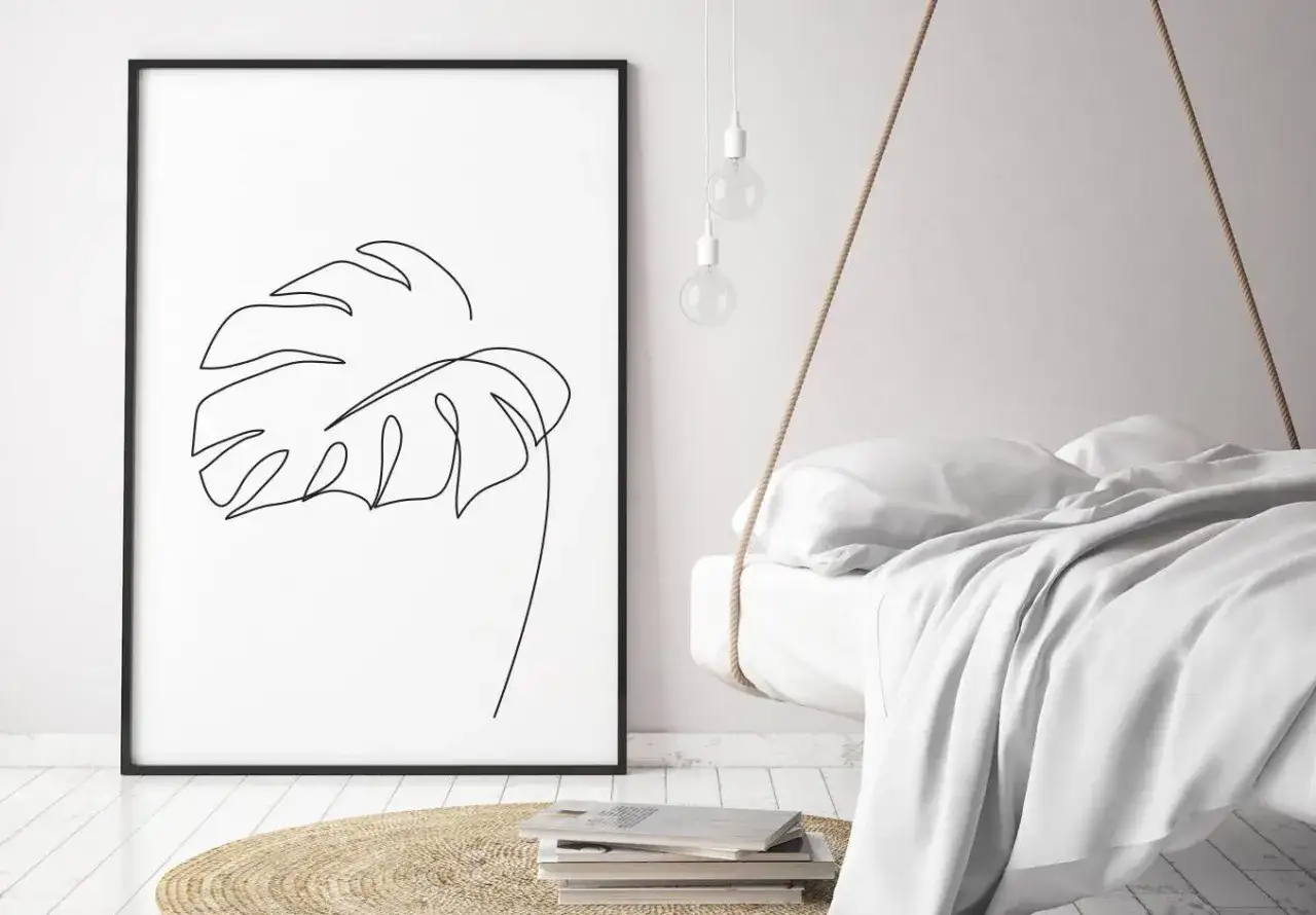 Gerahmtes Blatt-Linienkunst-Bild neben einem schwebenden Bett.