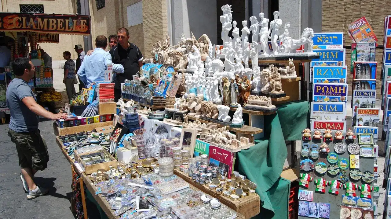 Stoisko z pamiątkami w Rzymie. Znajdziesz tu figurki, magnesy i książki. Idealne, co warto przywieźć z Włoch dla dzieci to małe repliki zabytków.
