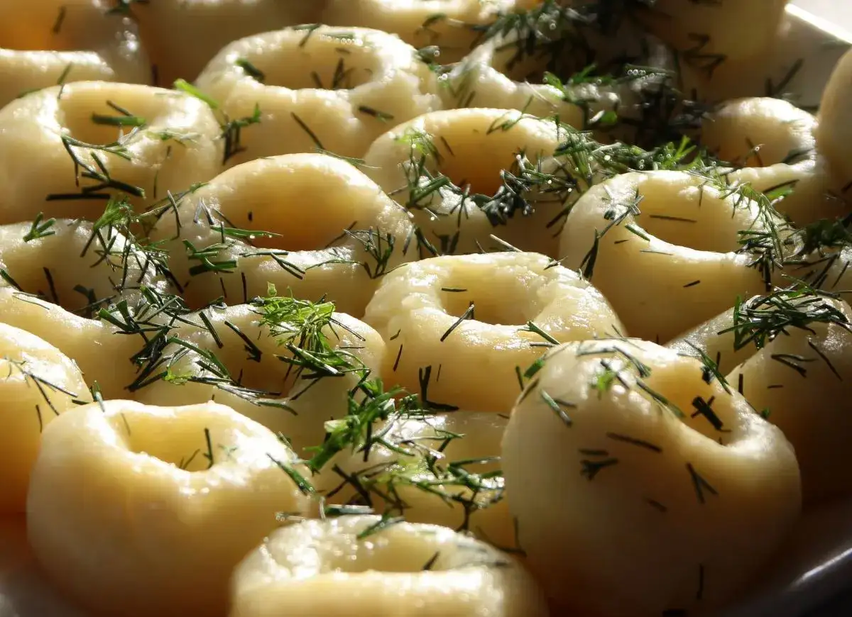 Kluski śląskie z koperkiem, ułożone na talerzu.