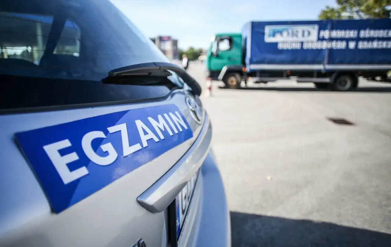 Samochód z napisem "EGZAMIN" na tylnej klapie. Czy głuchoniemy może mieć prawo jazdy? Tak, po zdaniu egzaminu.