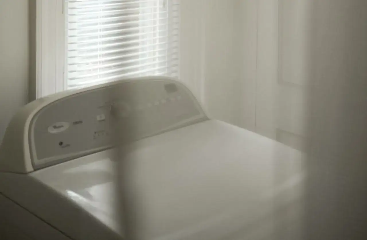 Górna część białej pralki ładowanej od góry z panelem sterowania.