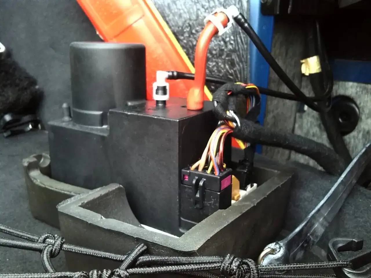 Pompka centralnego zamka Audi A4 B5 w bagażniku, widoczne przewody i złącza.