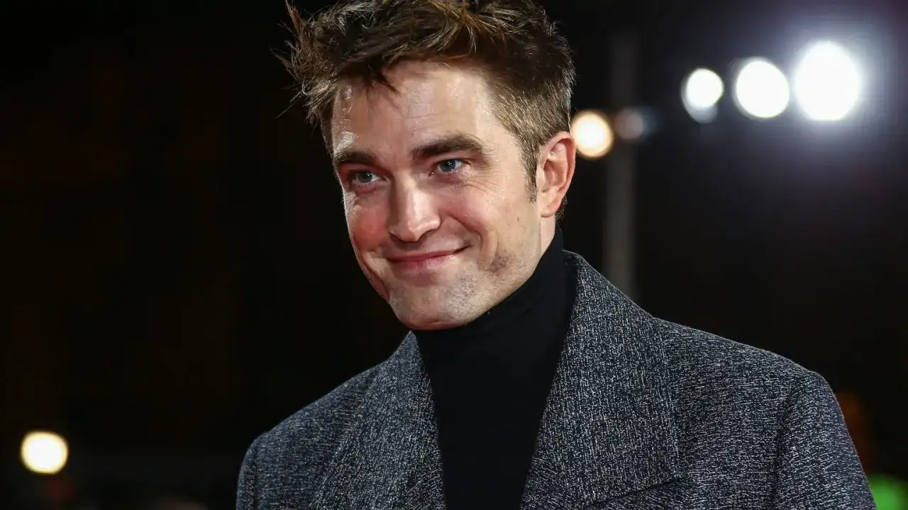 Robert Pattinson z uśmiechem, jakby wspominał swoje **dziecko**ństwo.