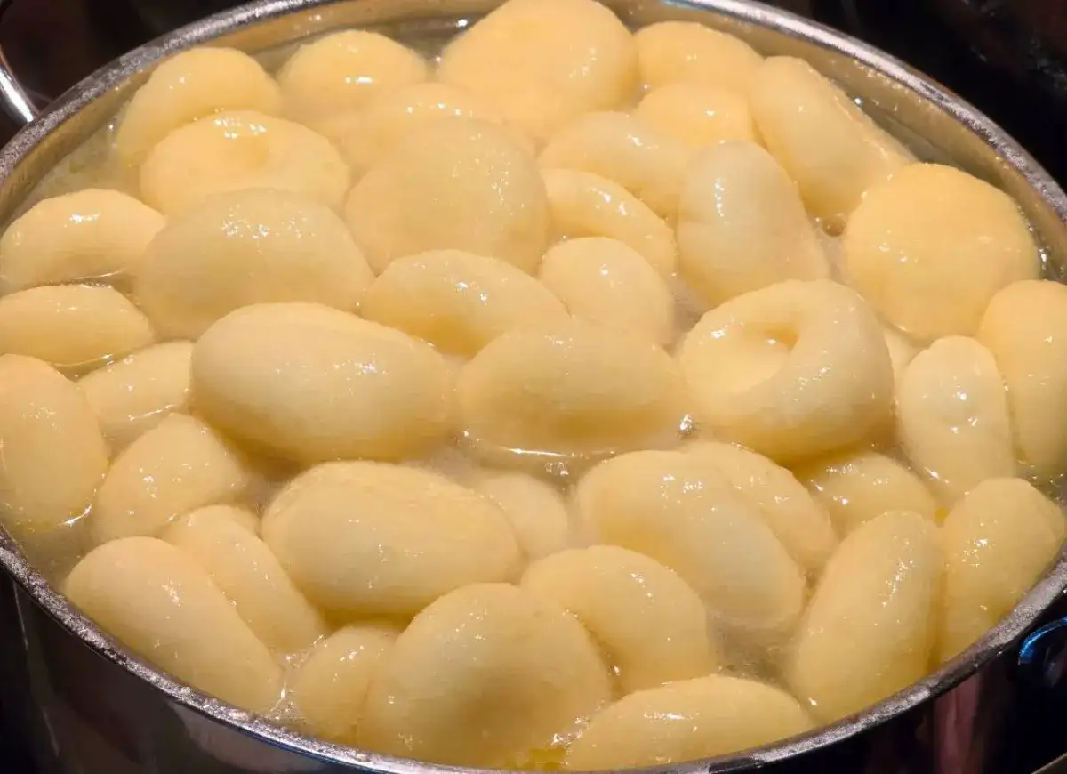 Kluski śląskie gotujące się w garnku z wodą.