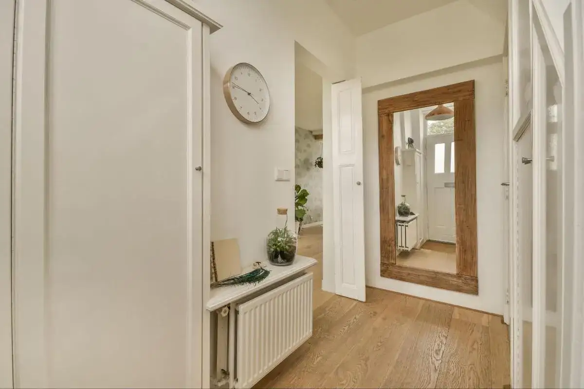 Duże lustro i jasne kolory pomagają rozjaśnić wąski korytarz. Zobacz, jak to zrobić!