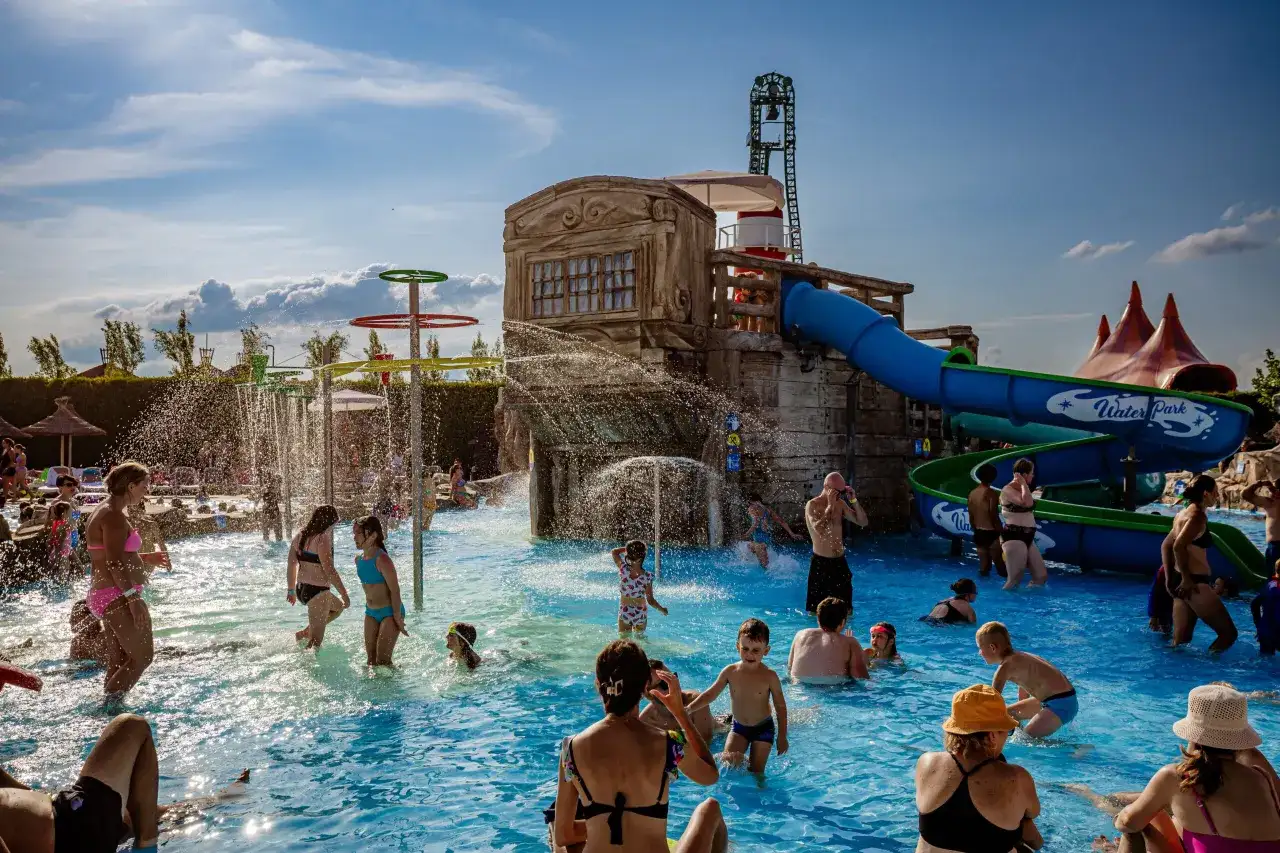 Rodzina cieszy się wodnym szaleństwem w parku rozrywki. Zastanawiasz się, ile kosztuje nocleg w Energylandii? Sprawdź ceny i zaplanuj wakacje!