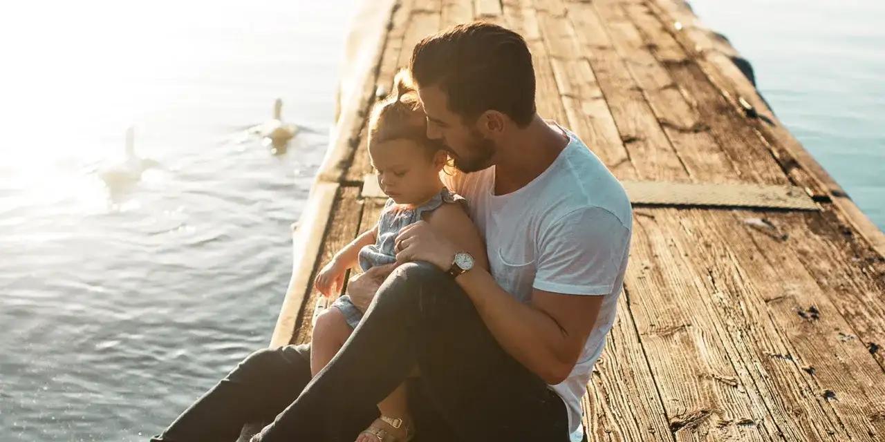 Ojciec tuli córkę na pomoście. Mimo rozstania, prawa ojca do dziecka bez ślubu są widoczne w tej czułej chwili.