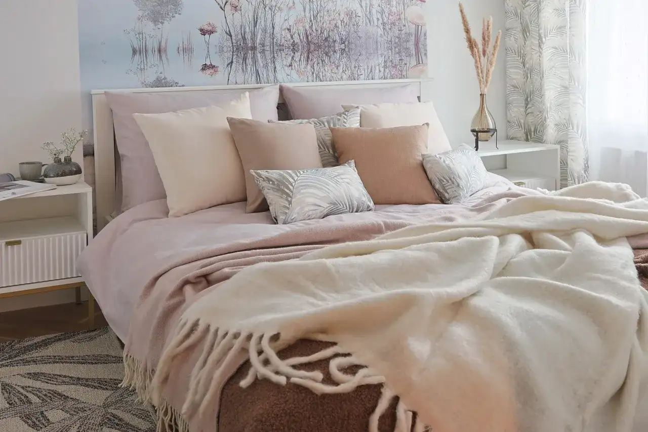 Małe i duże poduszki dekoracyjne na łóżku w sypialni