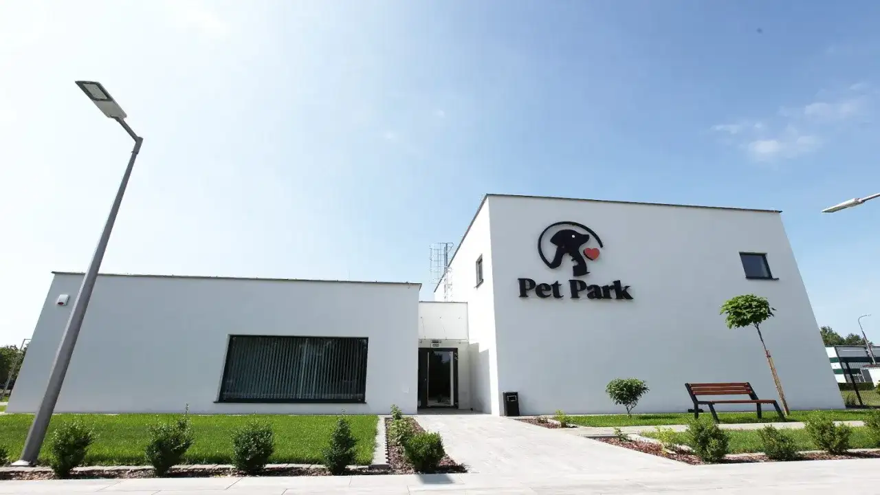 Nowoczesny budynek krematorium dla zwierząt "Pet Park" z logo i ławką.
