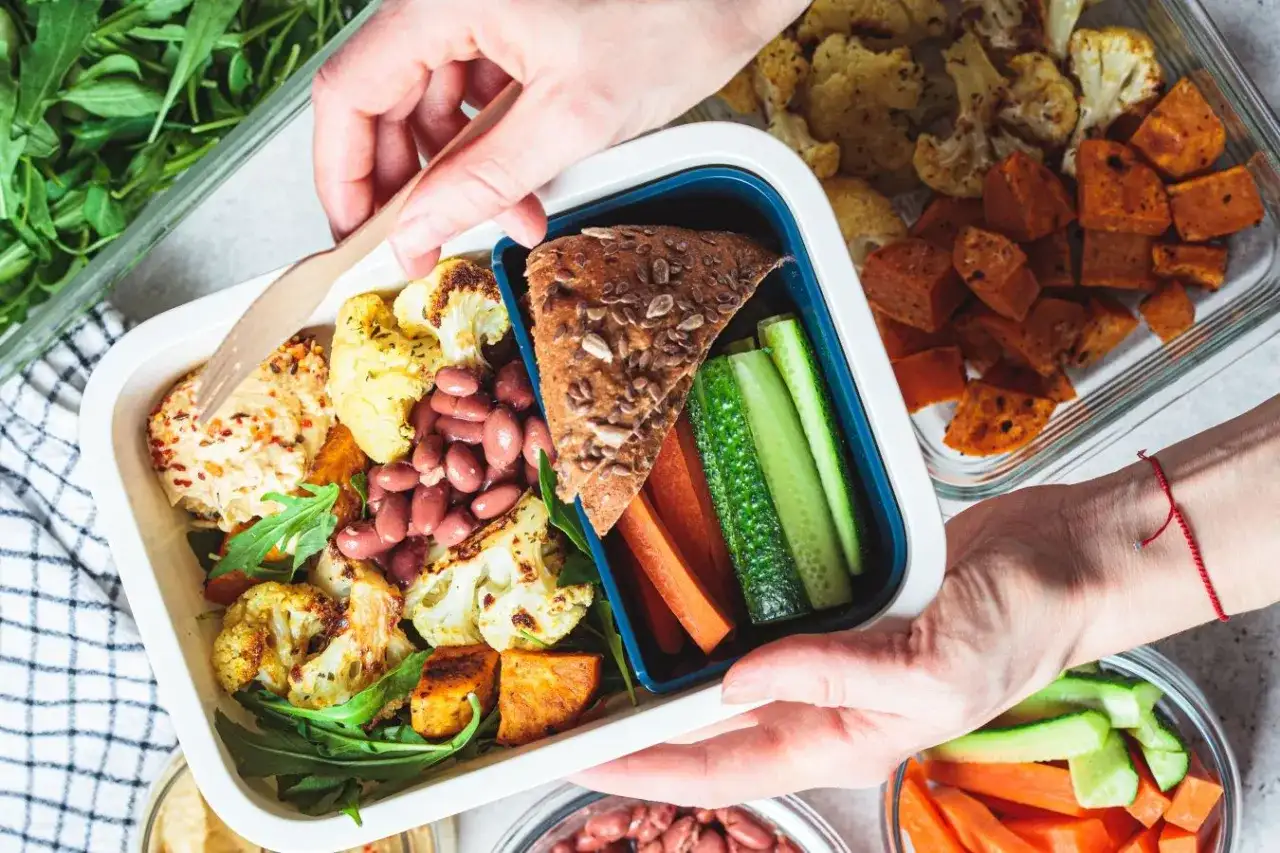 Zdrowa dieta pudełkowa dla dzieci: kolorowe warzywa, fasola, pieczone bataty i kalafior. Idealny lunchbox na wynos.