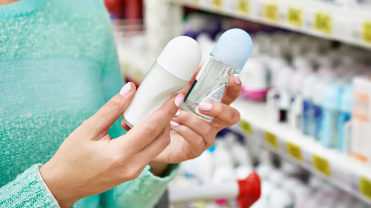 Kobieta trzyma dwa dezodoranty. Zastanawia się, gdzie wyrzucać opakowania po dezodorantach, by były ekologiczne.