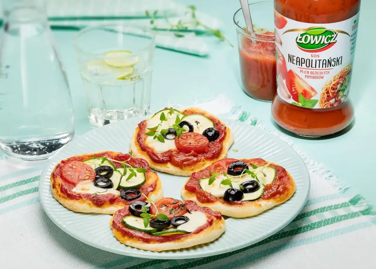 Pizzerinki z ciasta do pizzy, z sosem neapolitańskim Łowicz, mozzarellą, cukinią, oliwkami i pomidorkami.