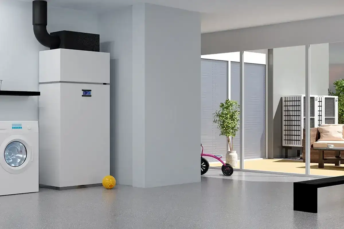 Nowoczesna pompa ciepła do domu 180m2 z grzejnikami, obok pralka i zabawki. Na zewnątrz widać taras z meblami.