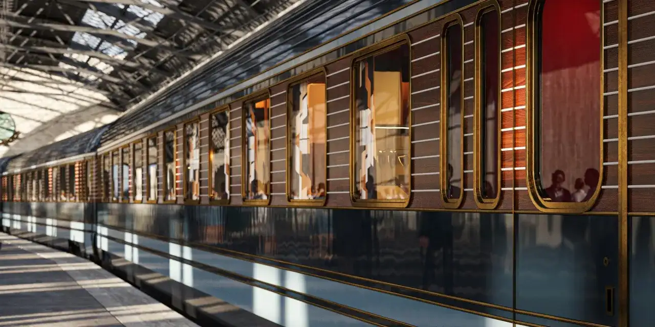 Luksusowy wagon Orient Express na peronie. Elegancka, drewniana okładzina i złote zdobienia zapowiadają niezwykłą trasę podróży.