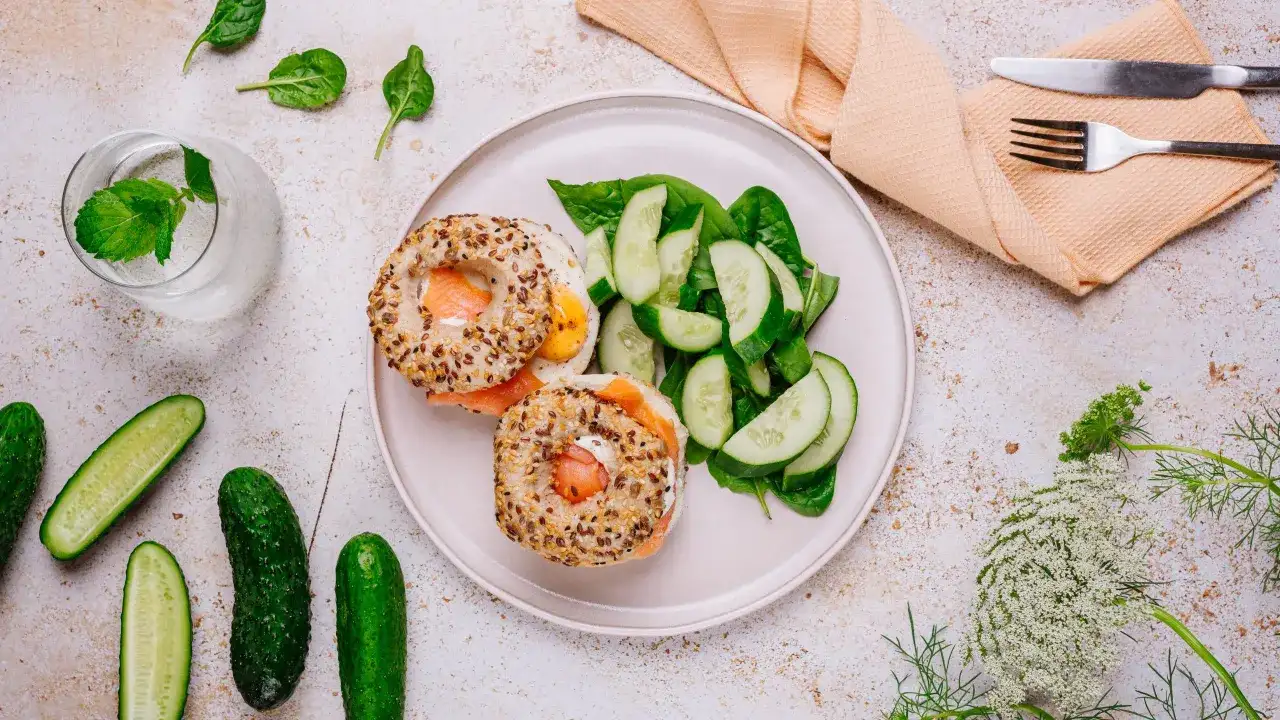 Bagiel z łososiem i jajkiem, sałatka z ogórka i szpinaku, woda z miętą.