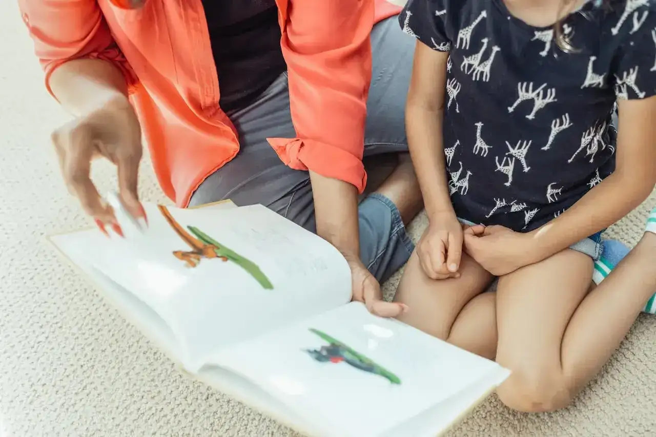Mama czyta dziecku bajkę o zwierzątkach, ćwicząc zmiękczenia w języku polskim.