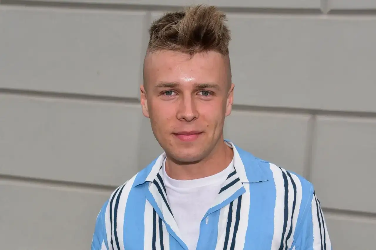 Młody mężczyzna z fryzurą na jeża, w koszuli w paski, wygląda jakby miał zagrać rolę w filmie. Czy Skolim jest aktorem?