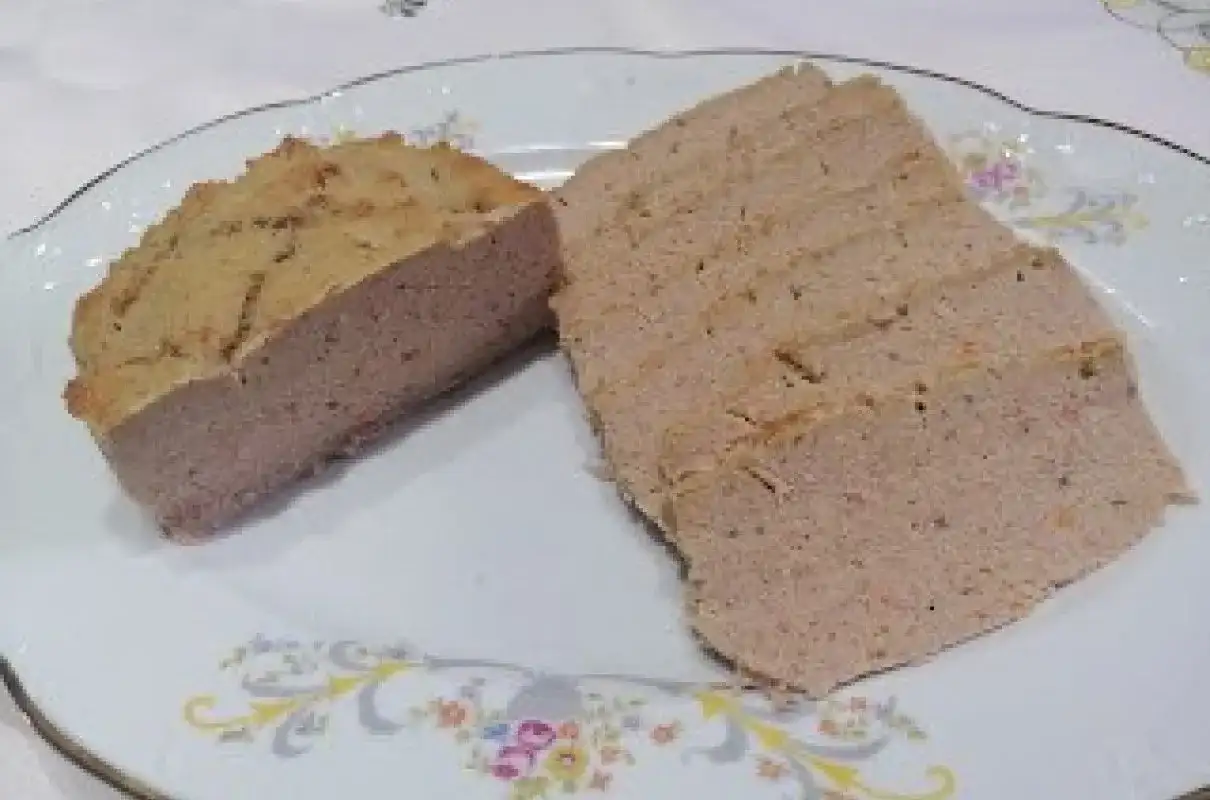 Pokrojony pasztet wieprzowy na talerzu z ozdobnym wzorem.