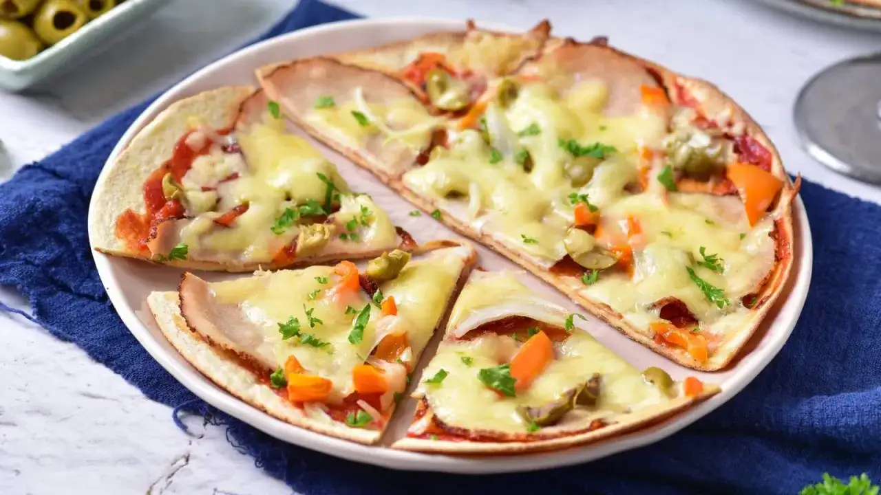 Pyszna pizza z szynką, warzywami i serem. Zastanawiasz się, bazylia co z niej zrobić? Dodaj ją do tej pizzy dla aromatu!