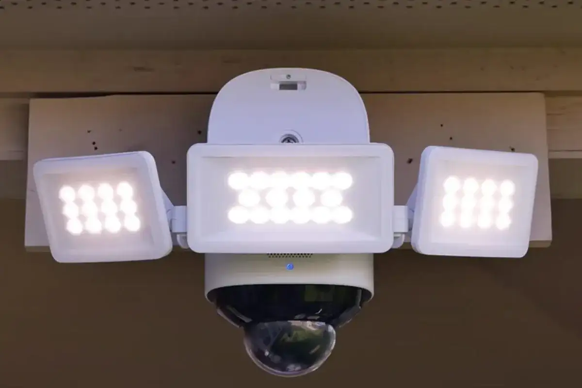 Biały naświetlacz LED z trzema panelami i kamerą kopułkową.