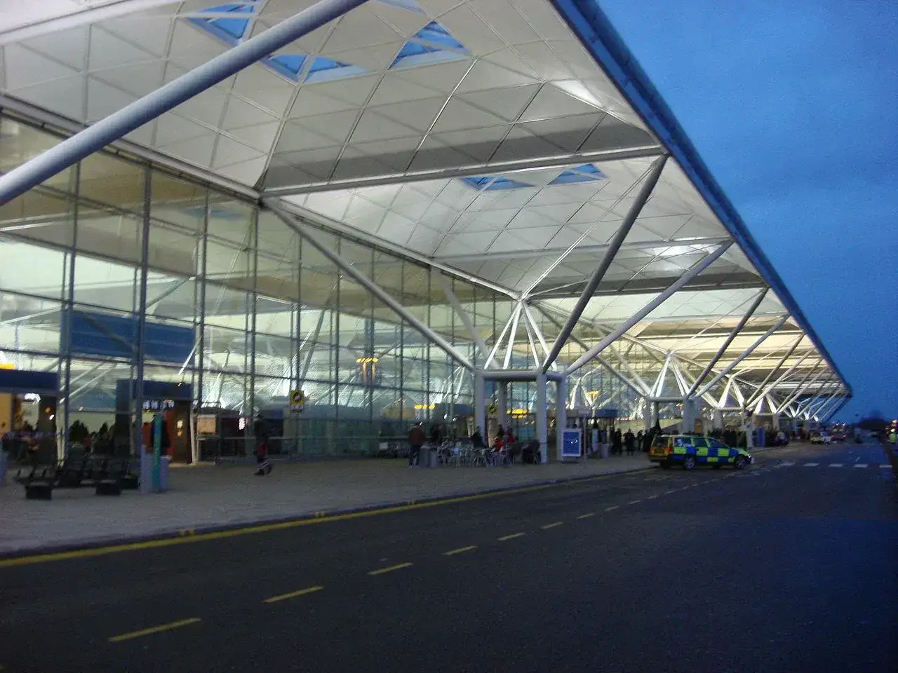 Nowoczesny terminal portu lotniczego Londyn Stansted STN z charakterystycznym dachem i szklanymi fasadami.
