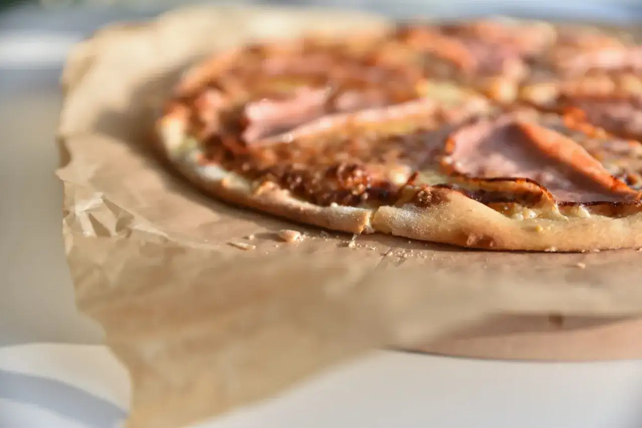 Apetyczna pizza na papierze. Zastanawiasz się, ile waży kawałek pizzy? Ten wygląda na idealny na szybką przekąskę.