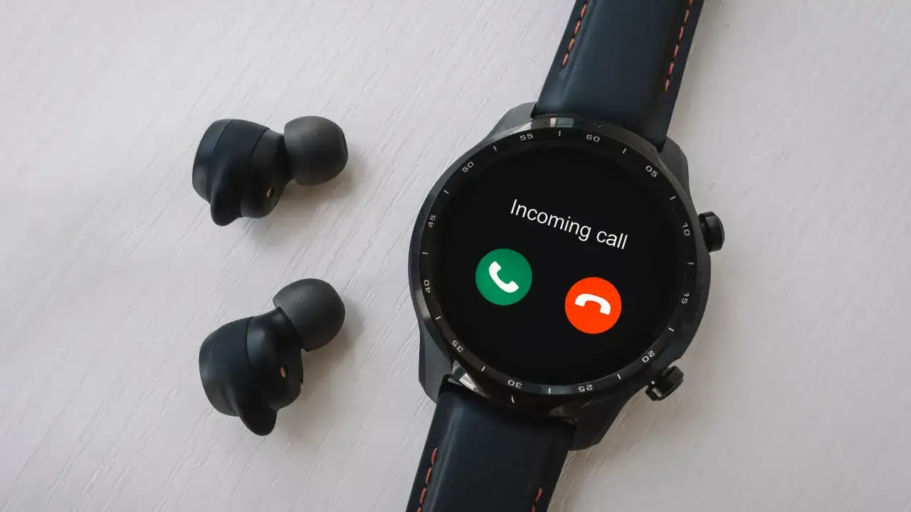 Czarny smartwatch z ekranem pokazującym połączenie przychodzące i bezprzewodowe słuchawki.