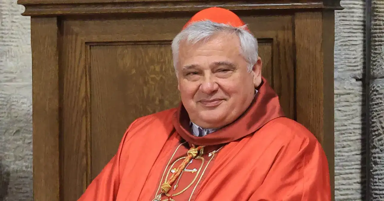 Uśmiechnięty kardynał w czerwonej sutannie i piusce. Kto jest nad biskupem? To on, w swojej uroczystej szacie.
