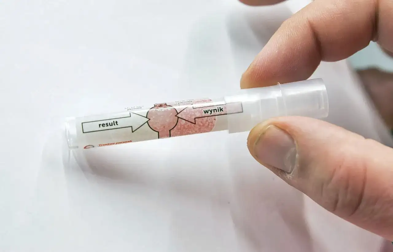 Palec trzyma jednorazowy alkomat. Czy w żabce jest alkomat? Wynik testu na trzeźwość.