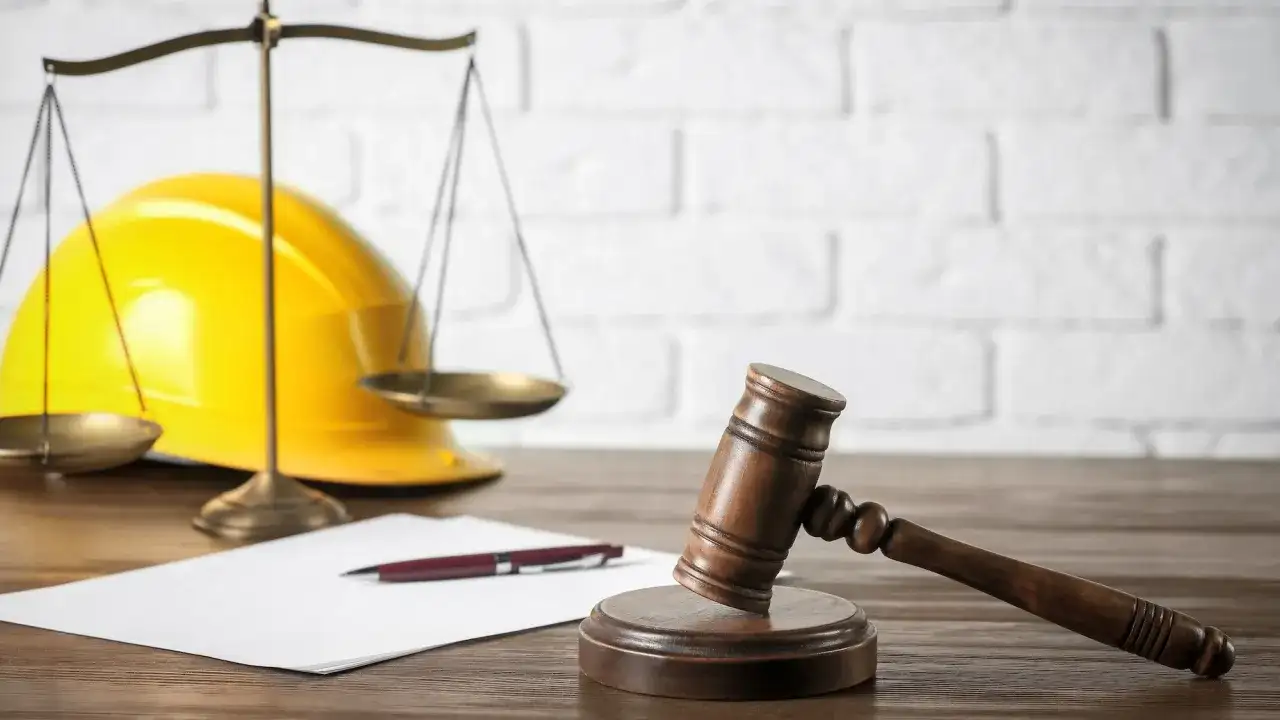 Młotek sędziowski, waga i żółty kask symbolizują, co potrzebne do pozwolenia na budowę domu.