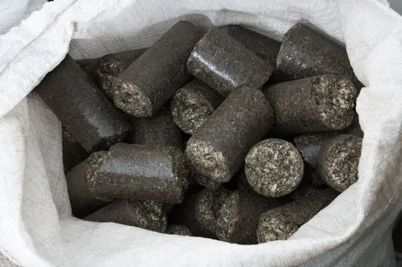 Worek pełen walcowatych brykietów, idealnych jako ekologiczne paliwo do pieca.