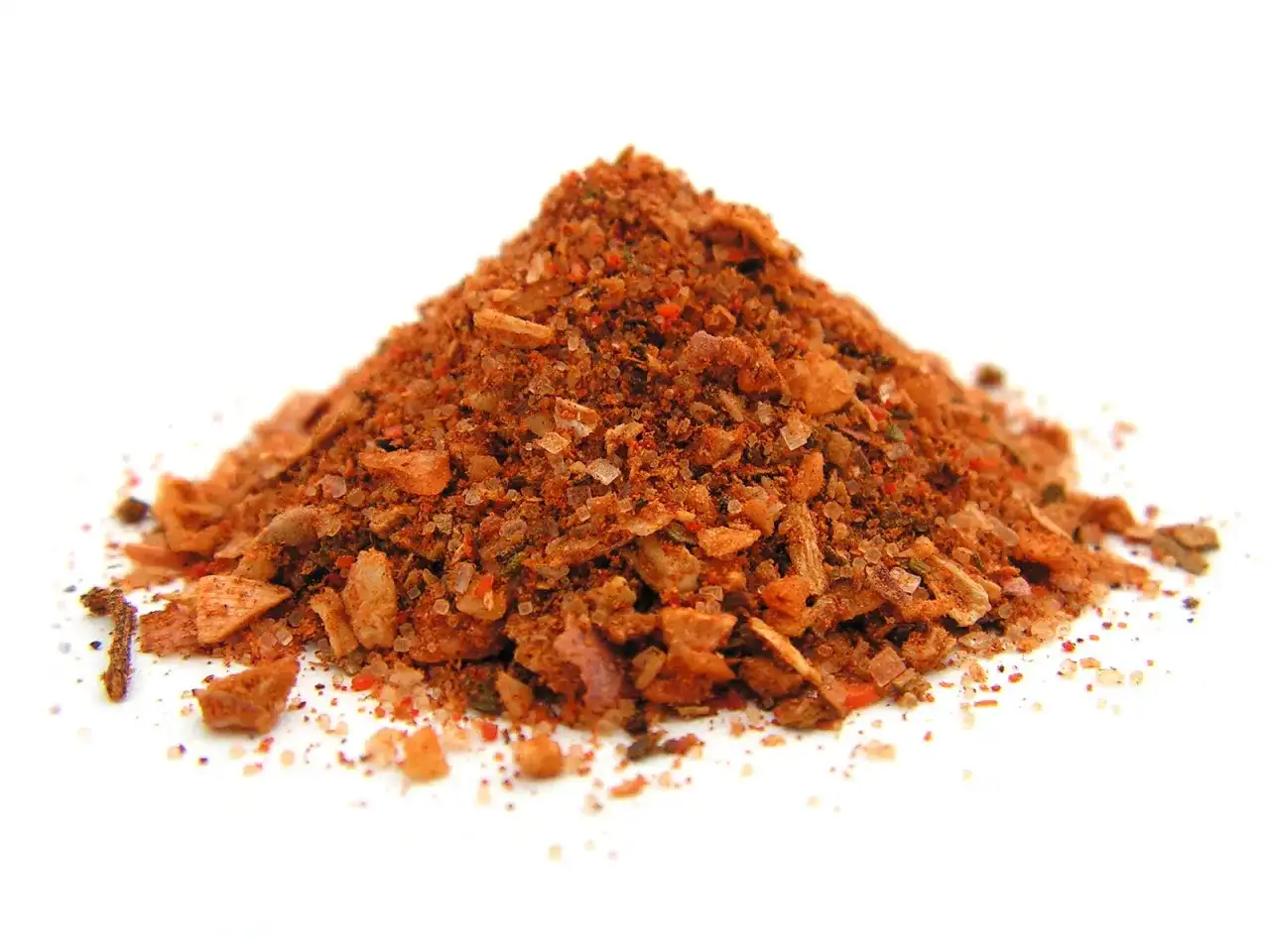 Góra przypraw do wieprzowiny, z widocznymi kawałkami soli, papryki i ziół.