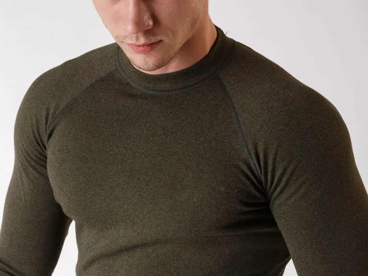 Mężczyzna w ciemnozielonej bluzce termoaktywnej z długim rękawem.
