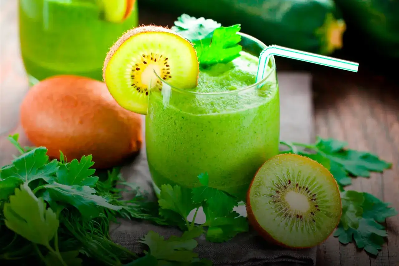 Zielony koktajl z kiwi i ziołami, udekorowany plasterkiem kiwi.