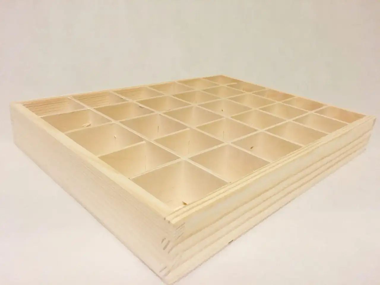 Pusta, jasna, drewniana skrzynka zamykana z 30 przegródkami, idealna do przechowywania drobiazgów.