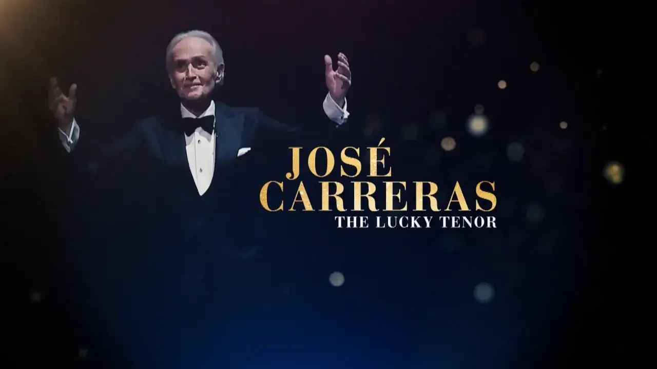 José Carreras w smokingu z uniesionymi rękami, na ciemnym tle z tekstem.