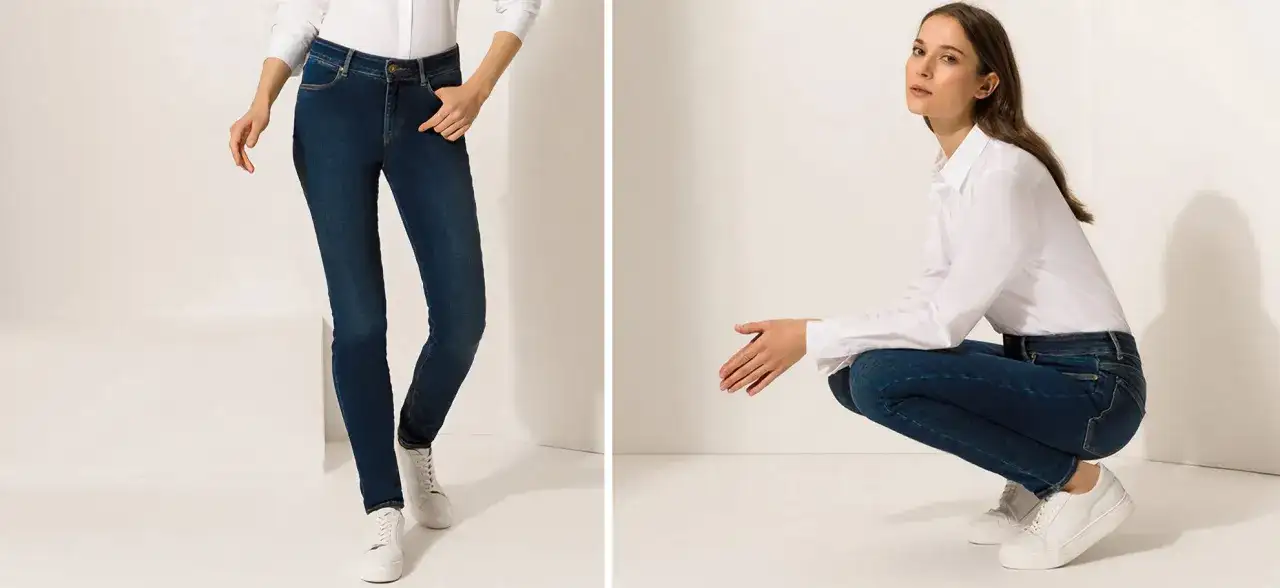 Zwei Frauen in Jeans und weißen Hemden, eine stehend, die andere hockend.