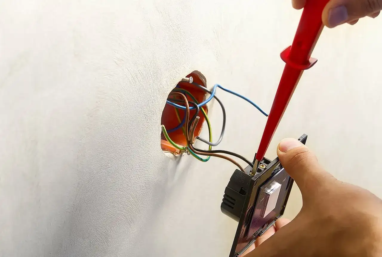 Instalator podłącza podwójny włącznik, pokazując, jak podłączyć dwie lampy do podwójnego włącznika.