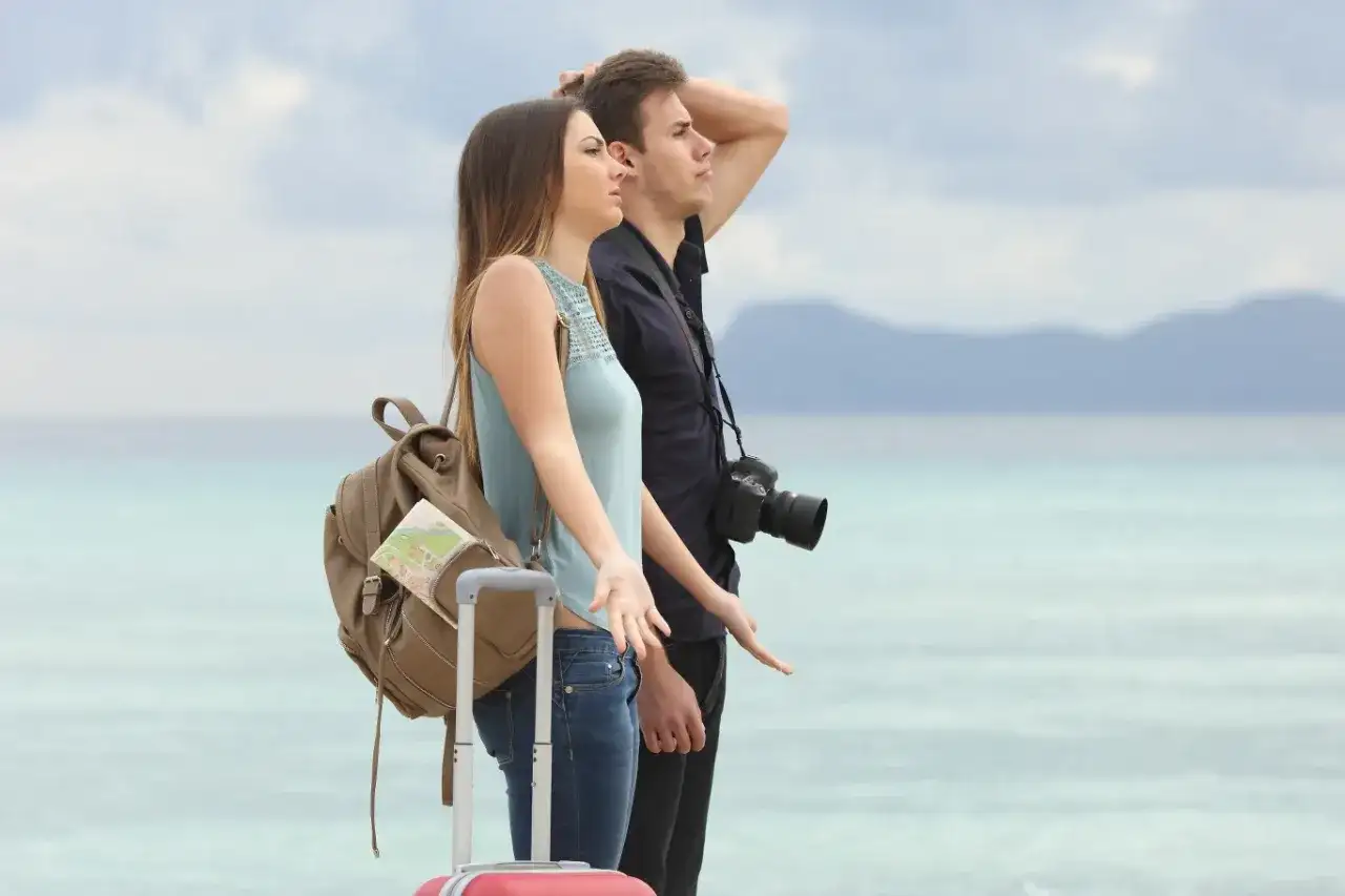 Rozczarowani turyści z bagażami, którzy być może czekają na odszkodowanie od biura podróży.