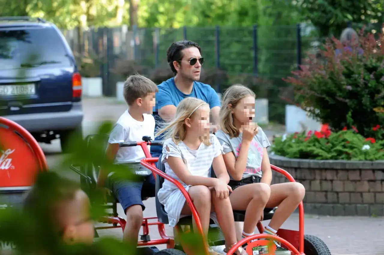 Marcin Dorociński z dziećmi na przejażdżce pojazdem gokartowym.