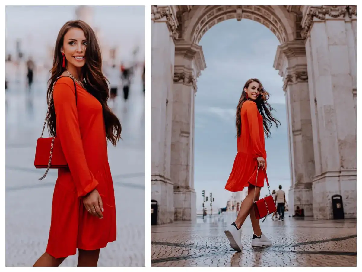 Elegancka, czerwona sukienka i torebka tworzą idealną stylizację na uroczystość rodzinną. Kobieta w ruchu pod łukiem.