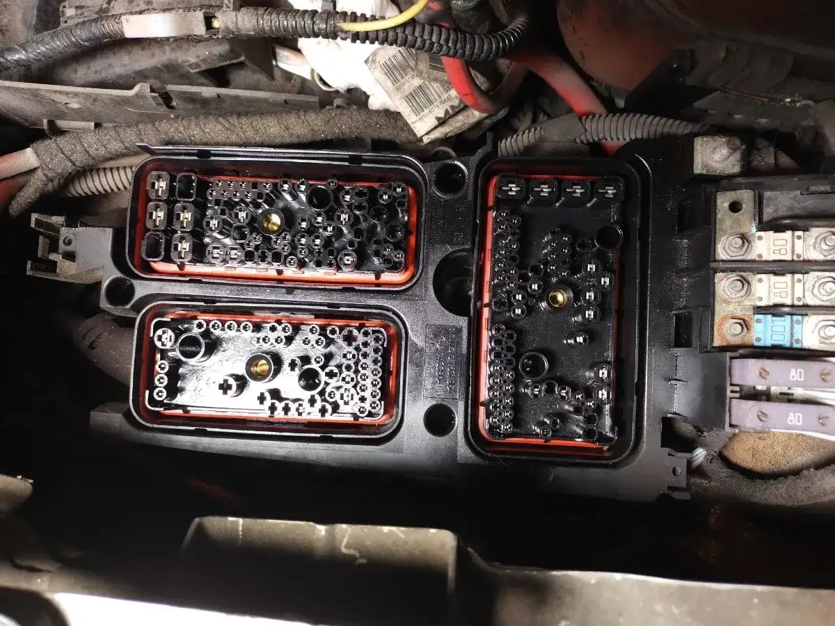 Wnętrze skrzynki bezpieczników w Oplu Zafirze B. Widoczne złącza i bezpieczniki, gotowe do diagnostyki.