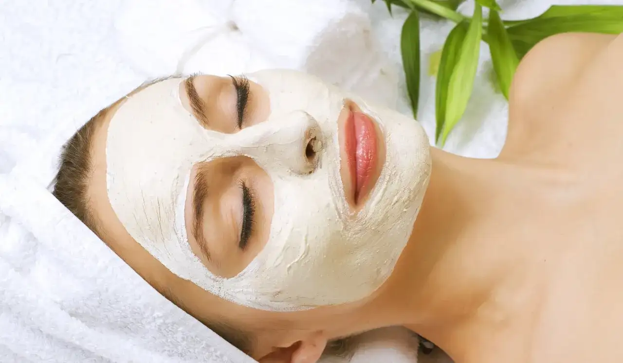 Kobieta z maseczką na twarzy, która zapewnia okluzję w kosmetyce, poprawiając wchłanianie składników. Relaks i pielęgnacja.