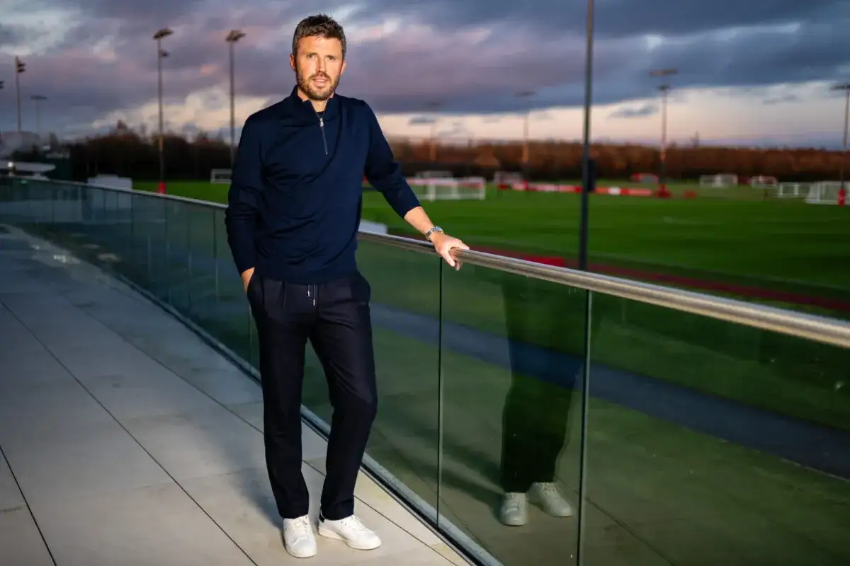 Michael Carrick, jeden z trenerów Man Utd, pozuje na tle boisk treningowych.