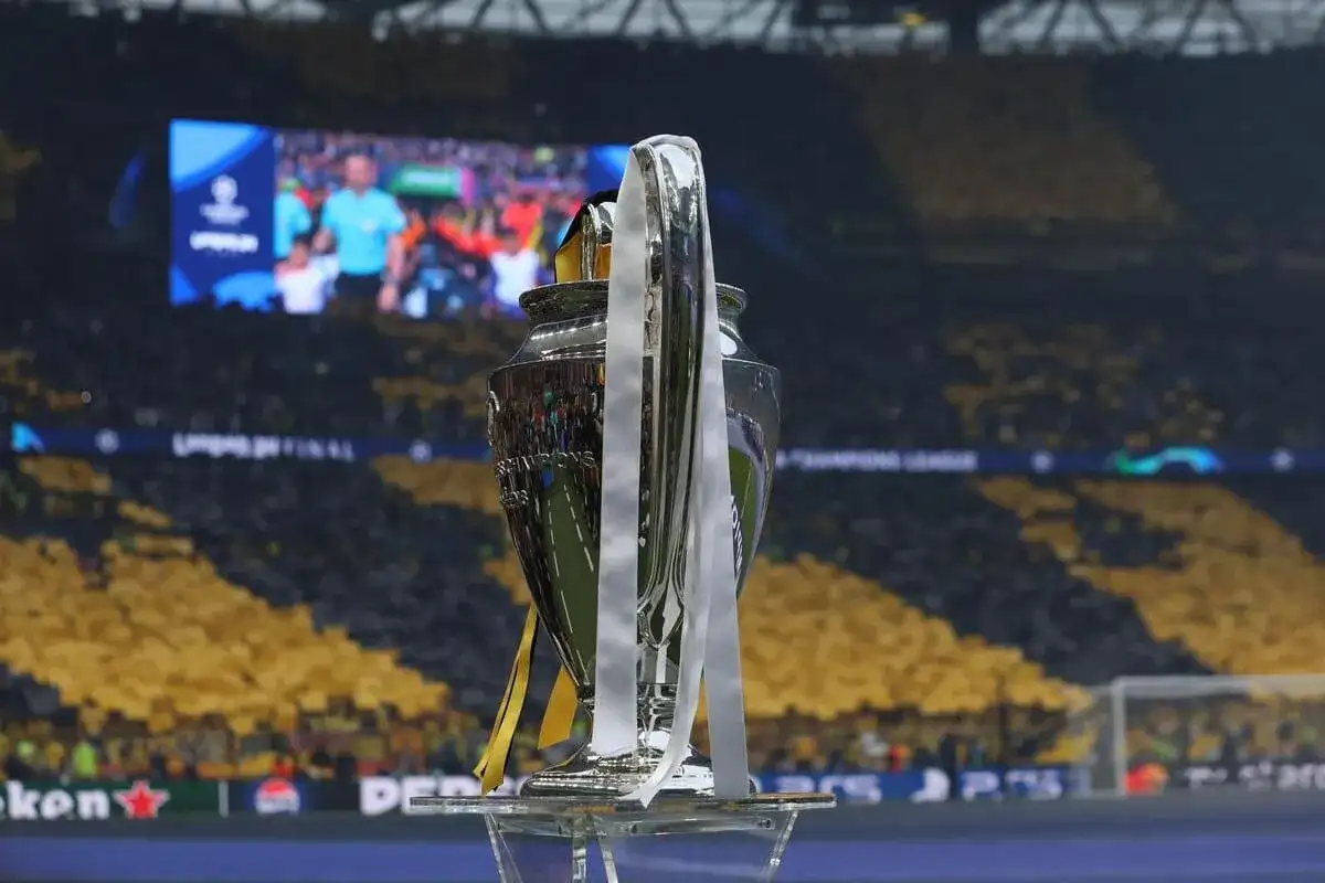 Trofeum Ligi Mistrzów na tle trybun. Kto wygrał ligę mistrzów? To pytanie zadają sobie kibice, patrząc na ten symbol zwycięstwa.