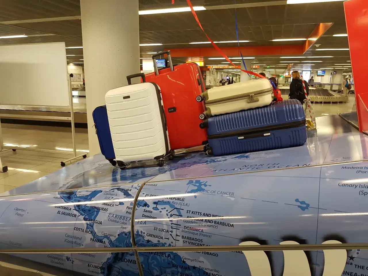 Stojaki z bagażami na mapie świata. Może to być symboliczna dzienna dieta za opóźniony bagaż, gdy podróżni czekają na swoje rzeczy.