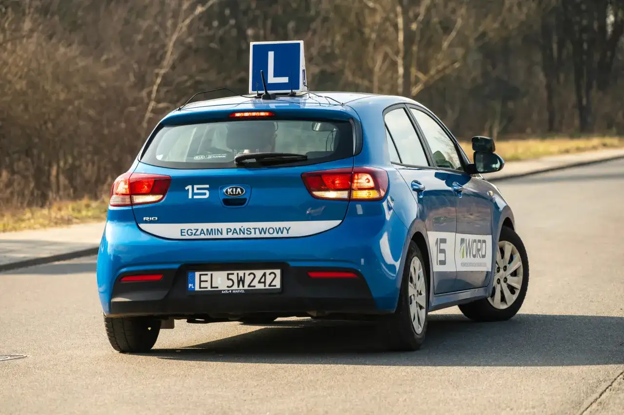 Niebieski samochód z literą "L" na dachu i napisem "WORD" na boku to idealne miejsce, gdzie można poćwiczyć jazdę samochodem w Warszawie.